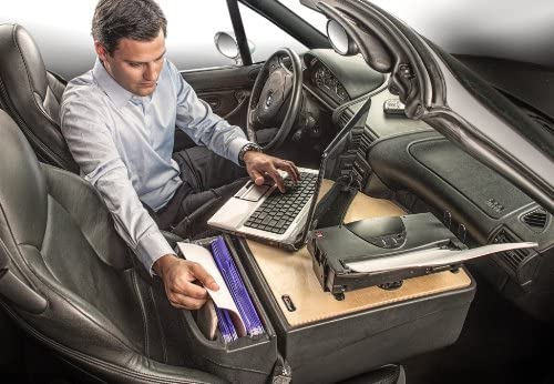 man using laptop in a car